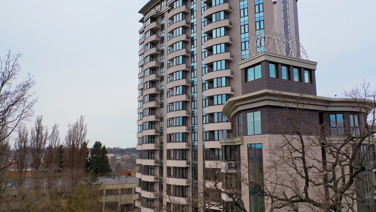 New multy-storey building in the city outside. Beautiful modern high-rise public housing apartments. Camera moves forward.