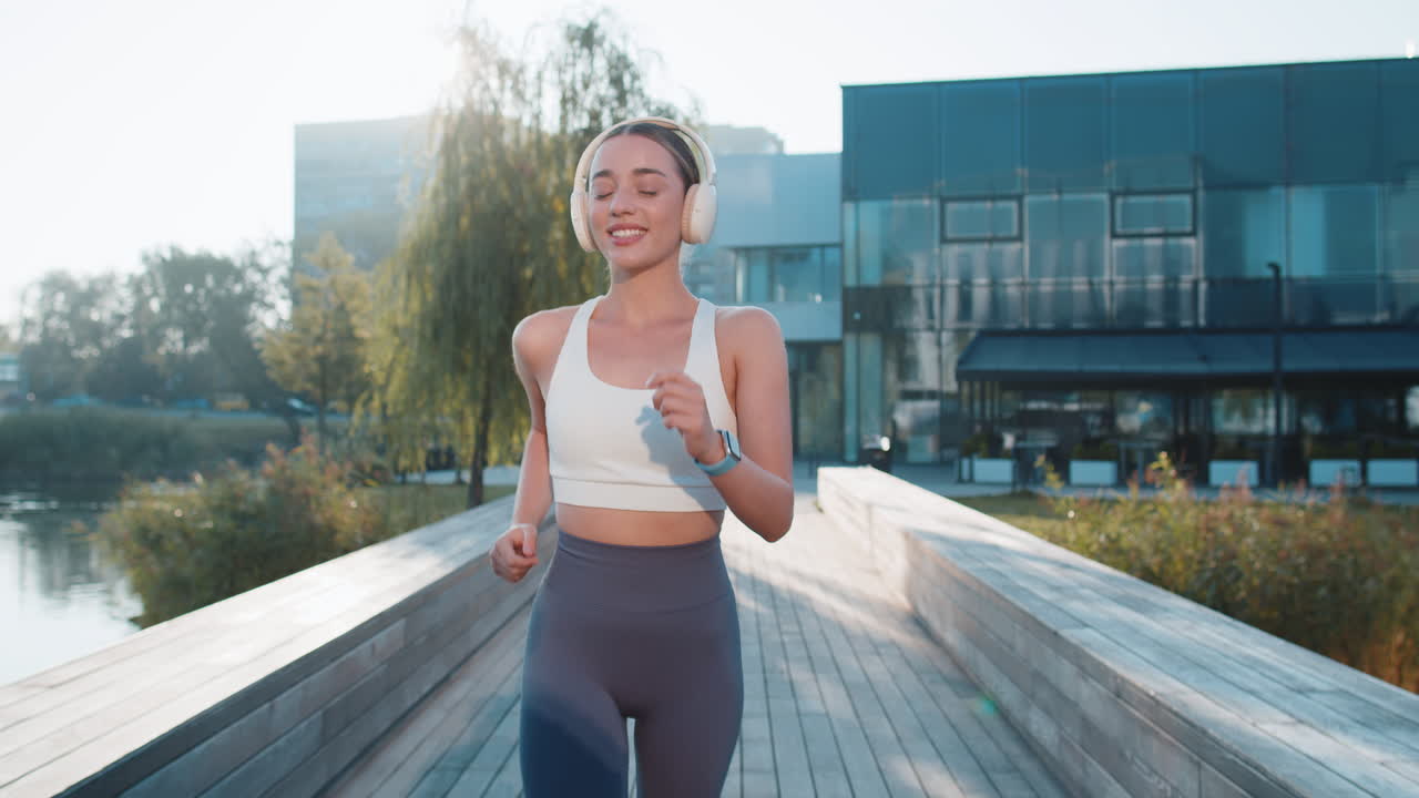활발한 스포츠 여성 조 훈련 마라톤 달리기 도시 공원에서 헤드폰으로 음악을 듣는