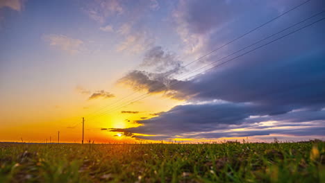 Ein-Gelber-Sonnenaufgang-In-Einem-Blauen-Himmel-über-Einem-Grünen-Feld