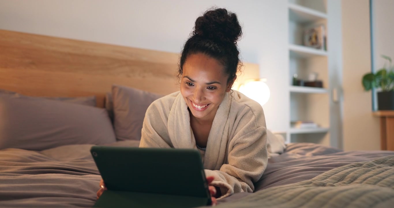 Ung Kvinde Bruger Tablet Mens Hun Slapper Af på Sengen