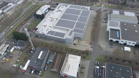 aerial tilting down to industrial rooftop filled with solar panels