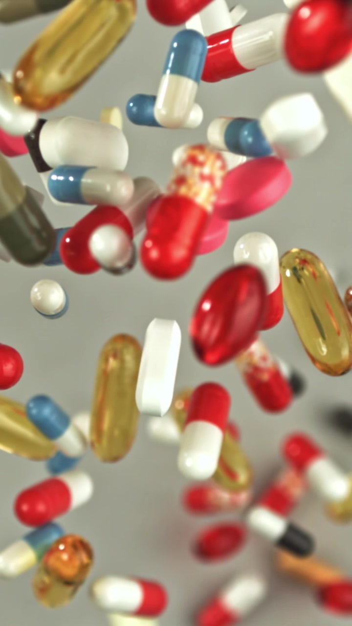 Colorful Pills and Capsules Falling in Slow Motion