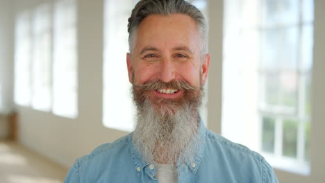 male comedian with a beard laughing at a funny