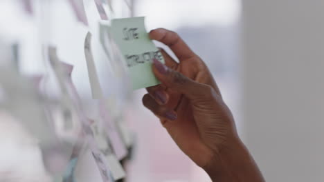 close up african american business woman using sticky notes brainstorming ideas problem solving with creative mind map planning strategy in office working on solution