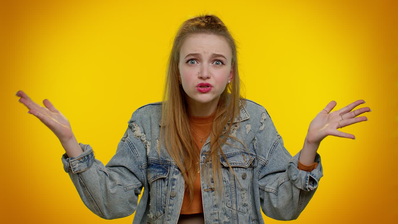 девушка поднимает руки с возмущенным выражением лица, спрашивая, почему, какая причина неудачи, демонстрируя неверие.