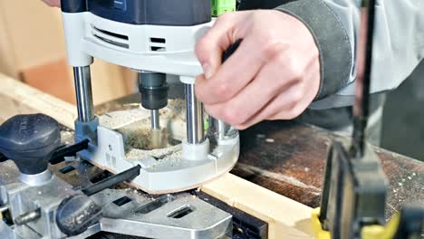 close-up of a carpenter's hand working with an manual electric cutter in a home workshop.