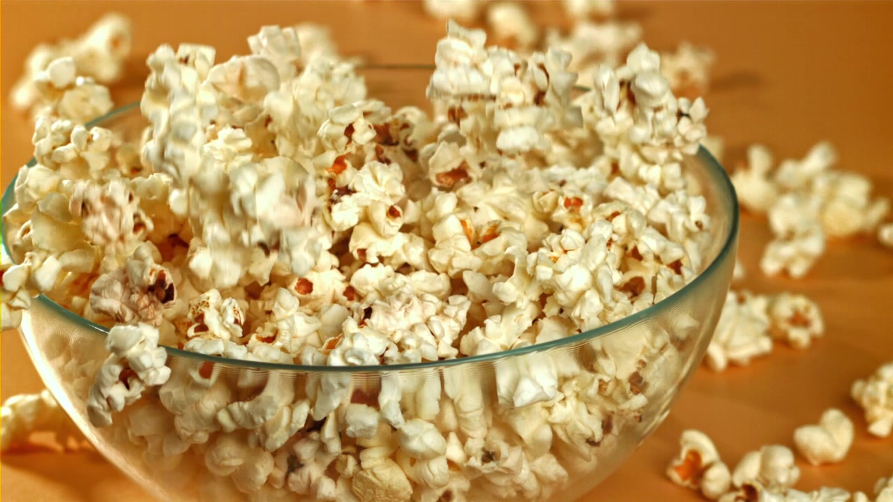 Popcorn Falling into a Glass Bowl on a Table