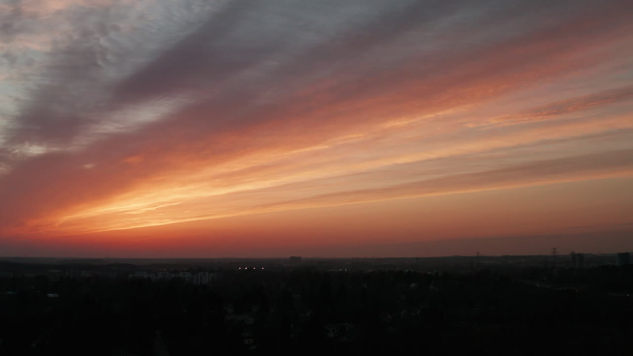 Aerial shot of the impressive moment after the sunset in Finland. Soothing linear cloud formation in the sky with warm golden colors.