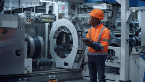 ingeniero afroamericano analizando datos de fábricas industriales trabajando en instalaciones