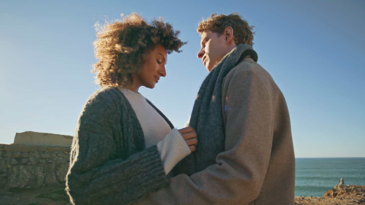 Diverse lovers cuddling together at sunny day closeup. People hugging at ocean