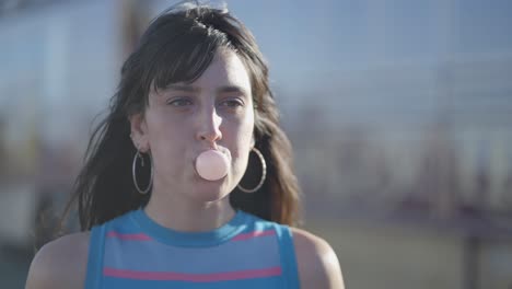 young woman blowing a bubble gum
