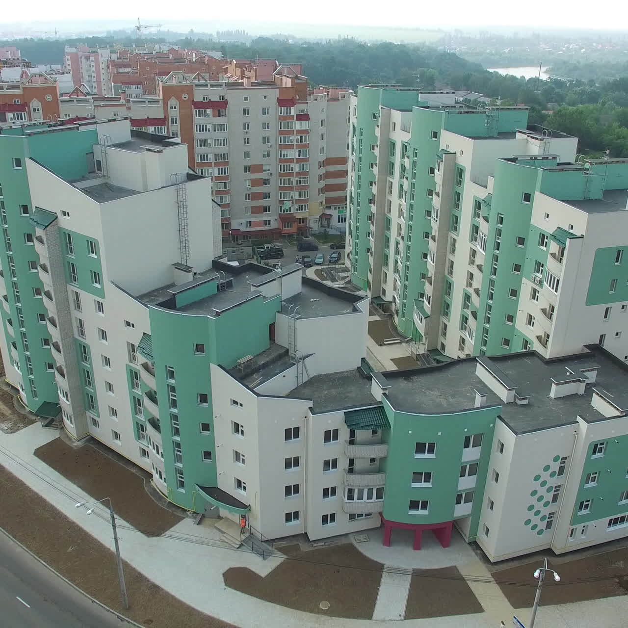 Modern multy-storey building in newly built district near the beautiful green landscape. New design for high structure. Camera motion bottom up
