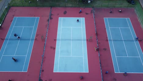 people in wheelchair playing tennis on court