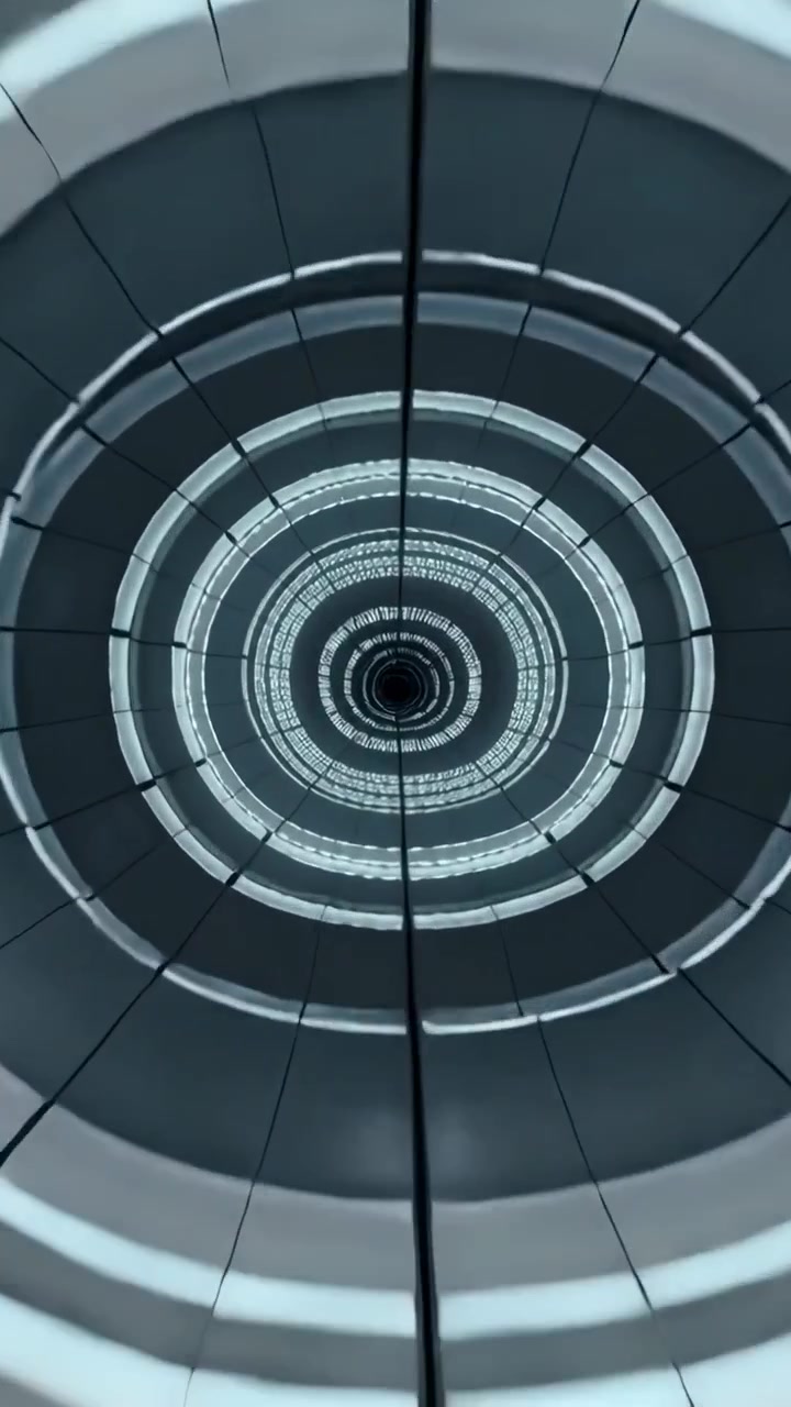 Video verticale: La telecamera avvia una panoramica, spostandosi verso l'apertura centrale dell'atrio, rivelando anelli di luce.