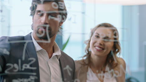 personas de negocios creativas escribiendo ideas en una pizarra de vidrio líder de equipo hombre haciendo lluvia de ideas con colegas trabajando en una solución discutiendo estrategia trabajo en equipo en la oficina reuniéndose a través de vidrio 4k