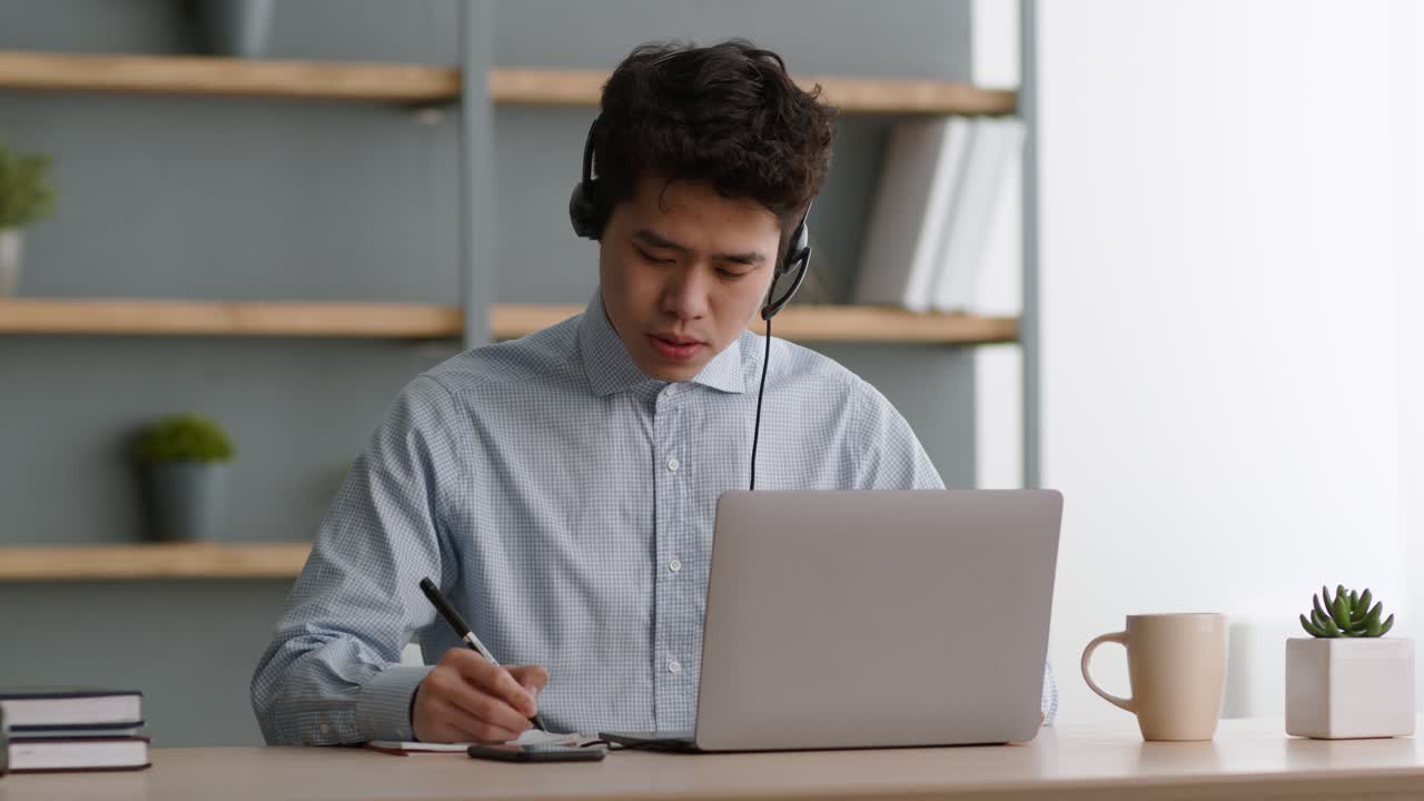 Young Man in a Video Call Taking Notes | Premium Stock Video Footage