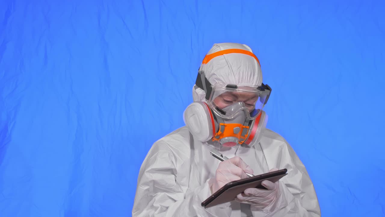인공호흡기에서 바이러스학자 과학자는 태블릿 컴퓨터에 스타일러스를 사용해 글을 쓴다. 보호 의료 마스크를 착용한 여성. 크로마 키 블루.