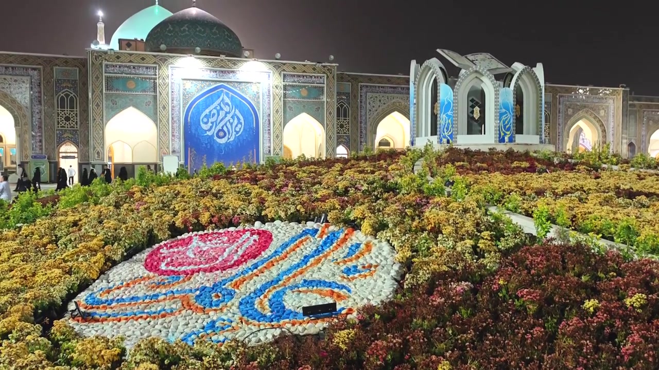 Jardim de Flores Iluminado em Frente a uma Mesquita à Noite