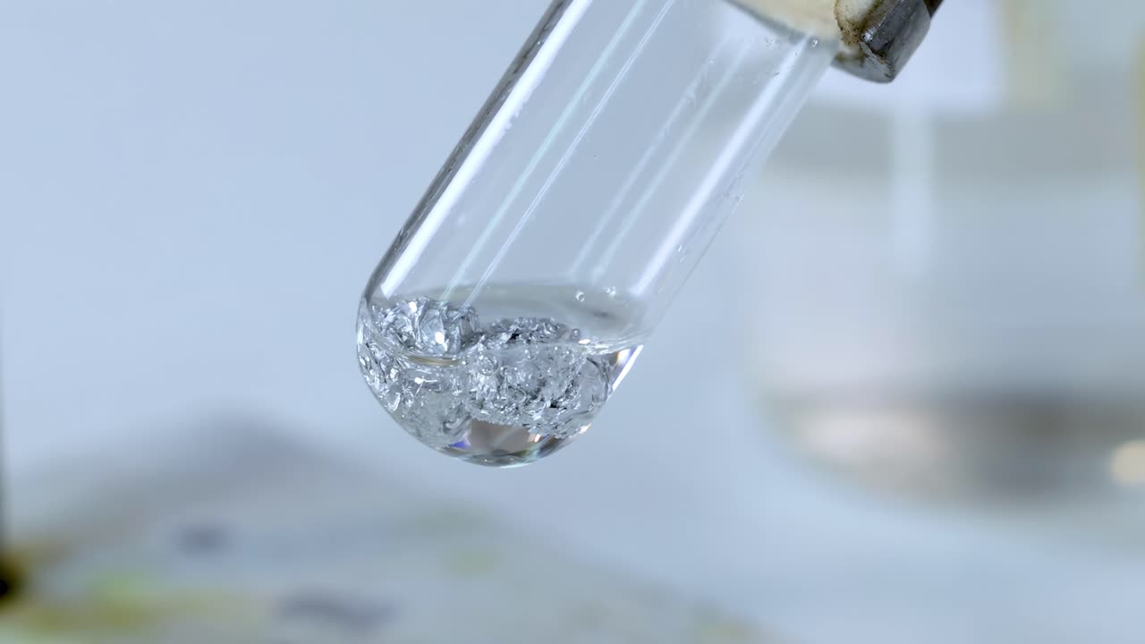 A detailed view of gas bubbles forming in a test tube during a chemical reaction.