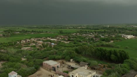 aerial pan shot of a lush village near mirpur khas, sindh, under stormy skies