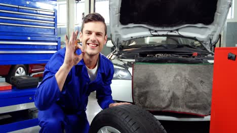 Mechanic-checking-tyre-and-making-ok-sign