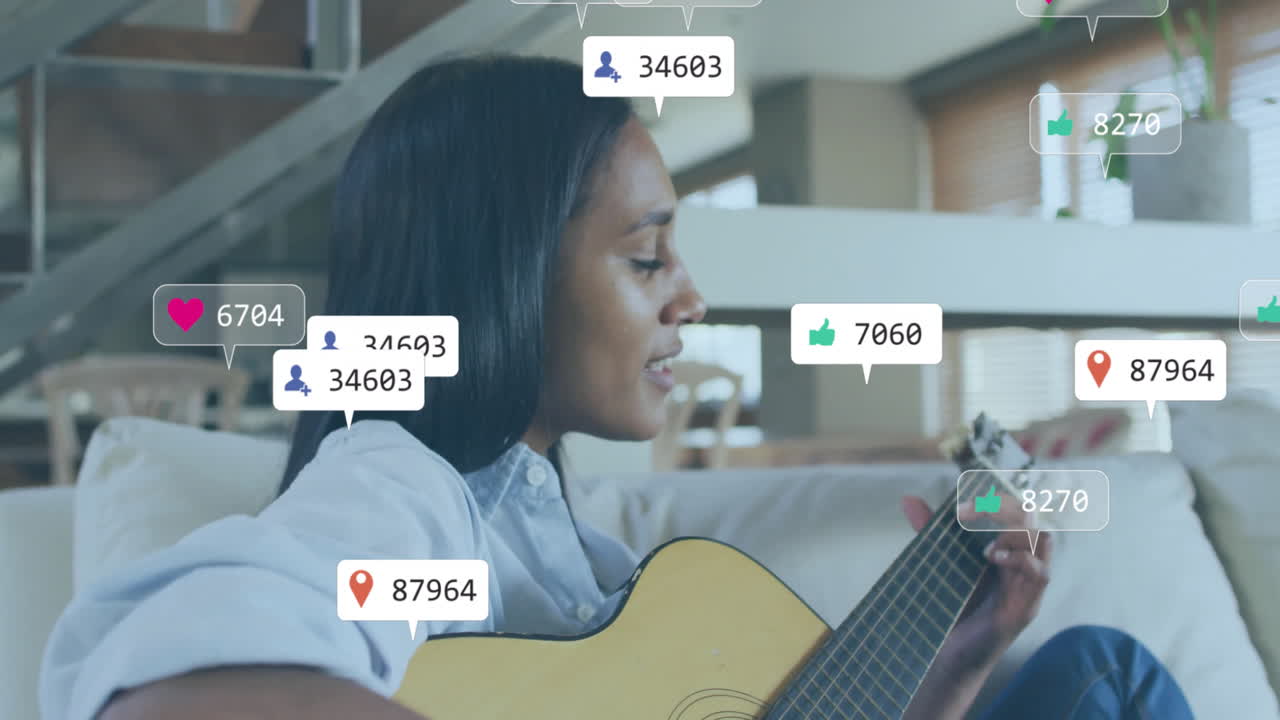 Animation of media icons over biracial woman playing guitar on couch