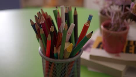 a cup of colored pencils on a desk