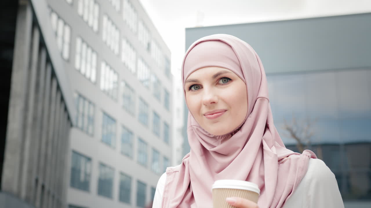 mujer de negocios en hijab tomando un descanso para un café en una ciudad moderna