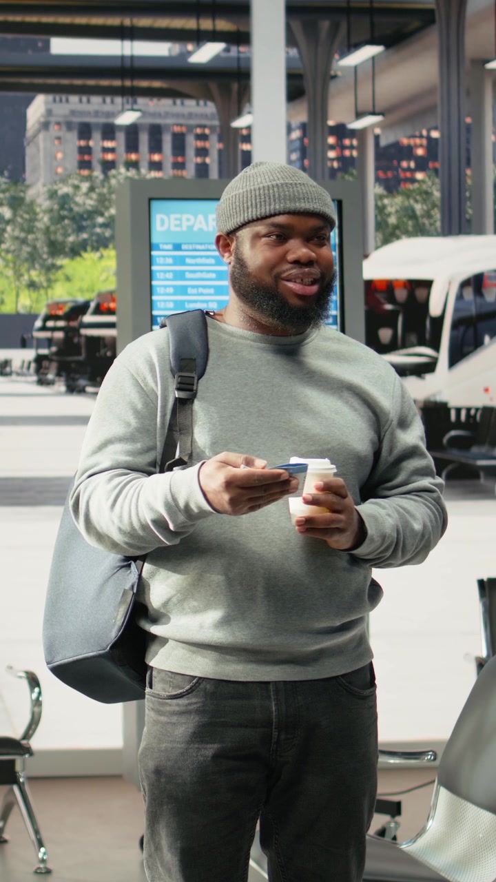 Young Man Waiting at Airport Terminal with Coffee and Smartphone