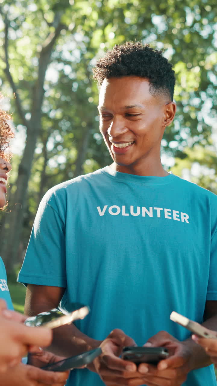 Happy Young Volunteer Man Using Mobile Phone Outdoors