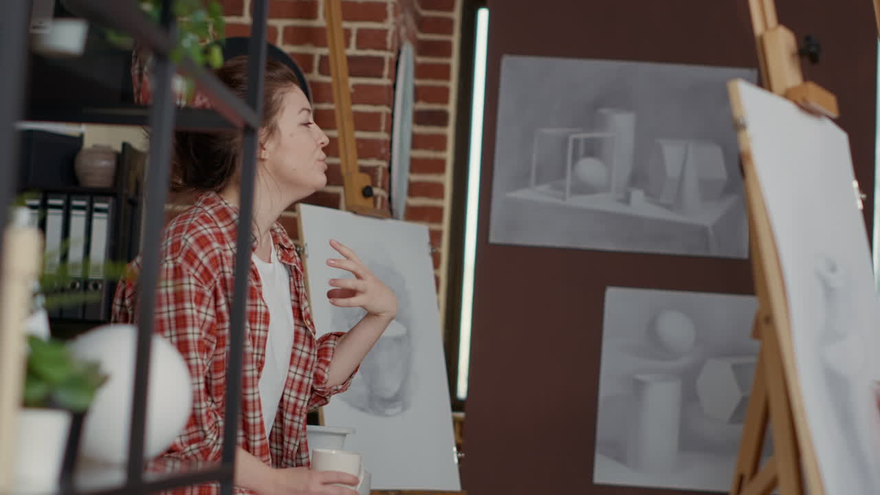 Female artist using vase model to explain drawing technique