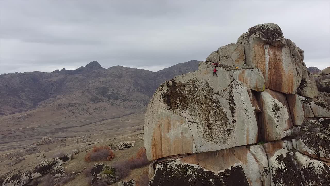 Rescue team climbers hanging on a massive vertical rock securing the equipment