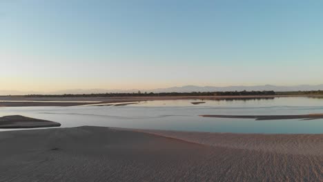 vista aérea de 4k del río brahmaputra durante la hora dorada del invierno con las montañas del himalaya al fondo