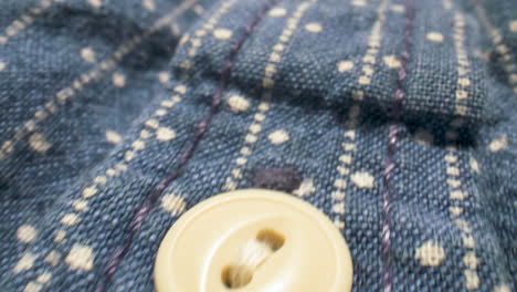 Close-up-slide-along-the-buttons-of-a-denim-shirt