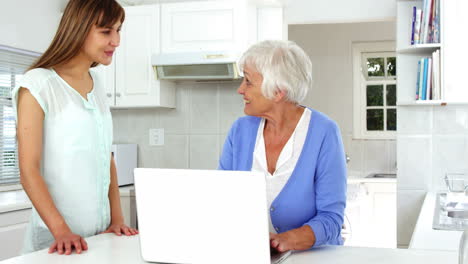 Mature-woman-using-laptop-and-talking-with-a-woman