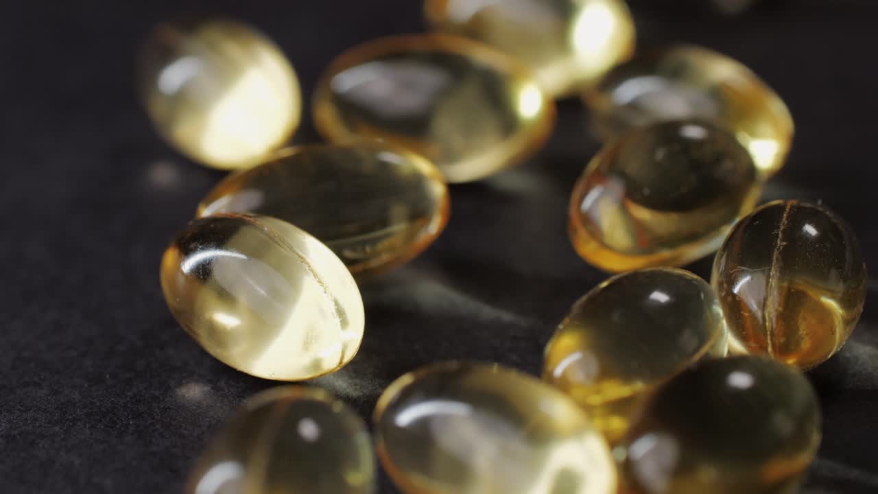 Omega fish oil gel capsules on black background close-up . Omega vitamins pills 3 6 9. To be healthy and take care of your health. Pharmaceutical industry. Business of biological supplements and vitamin. High quality 4k footage