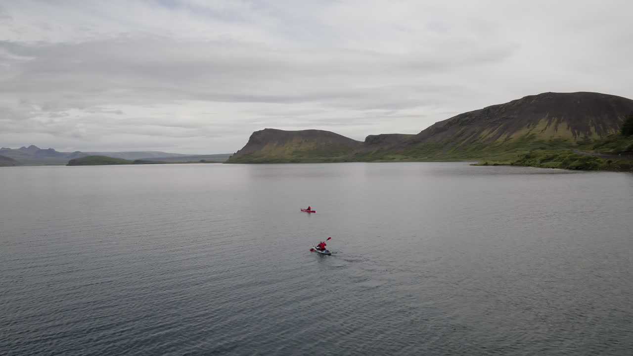 antenas del lago hestvik y el paisaje en islandia siguiendo a los kayaks mientras se dirigen hacia la distancia