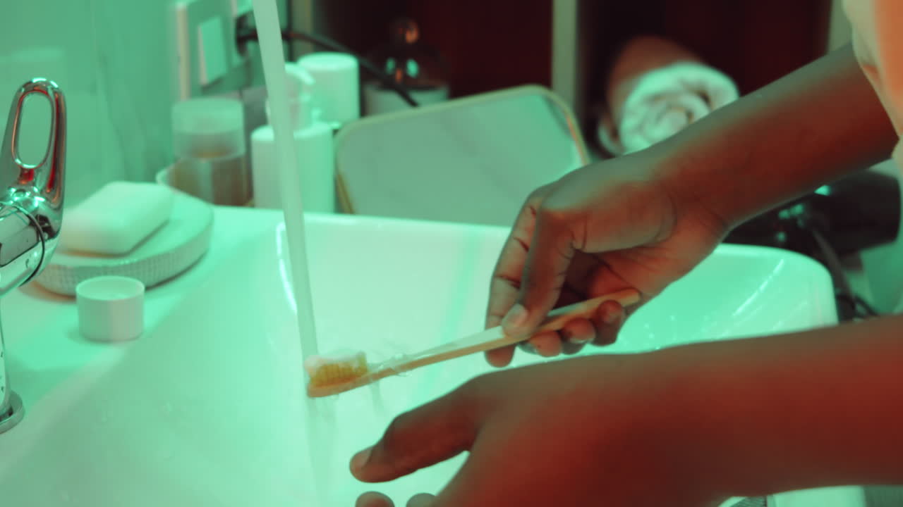 African American Woman Brushing Teeth in Bathroom