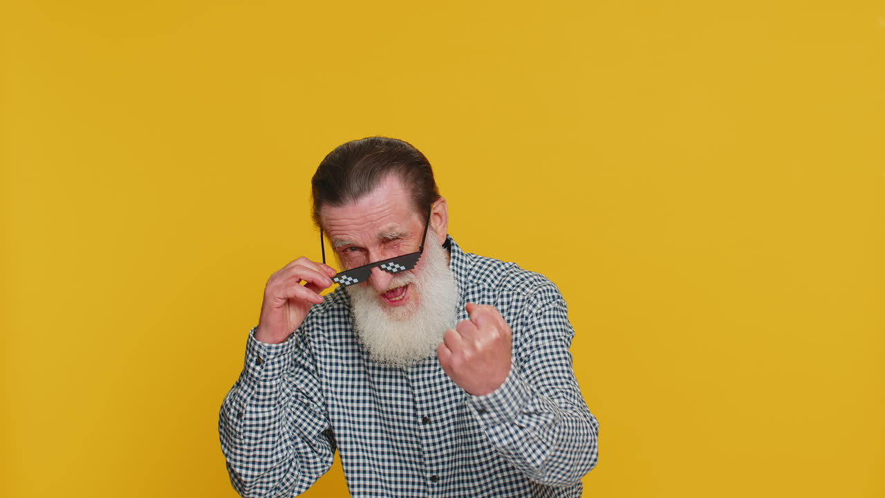 세련된 선글라스를 입은 행복한 노인이 음악을 듣고 춤을 추고 디스코에서 승리를 축하하고