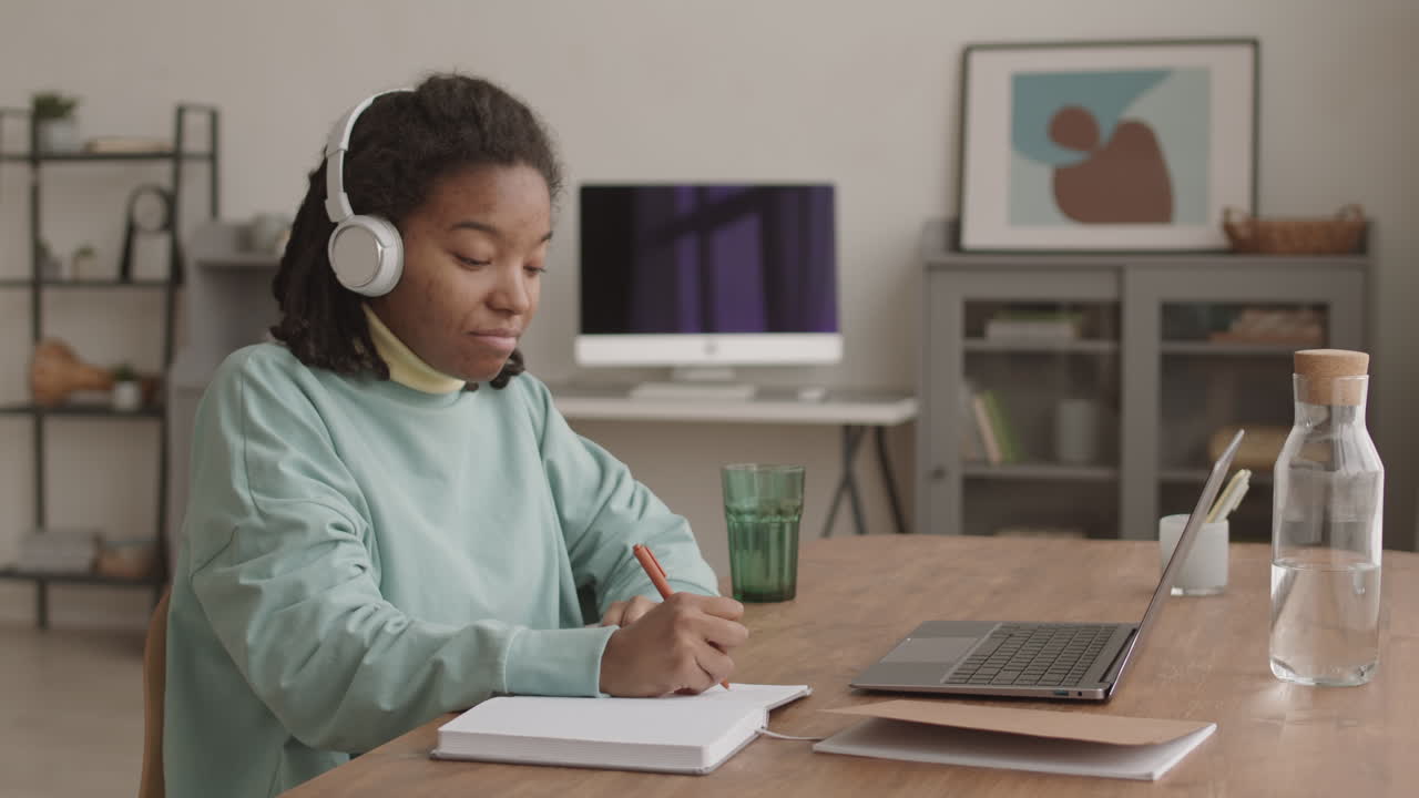 African Girl Doing Homework and Listening to Music