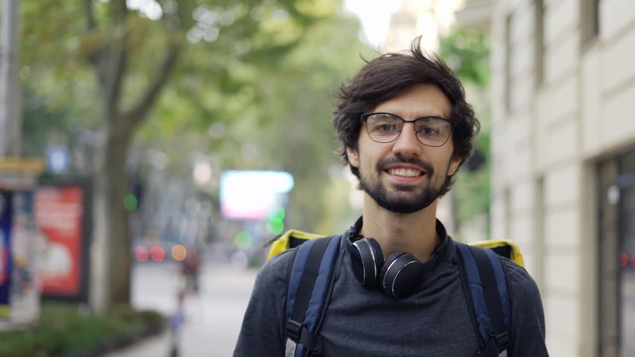 retrato de un joven guapo y alegre del servicio de entrega de alimentos con una gran mochila térmica