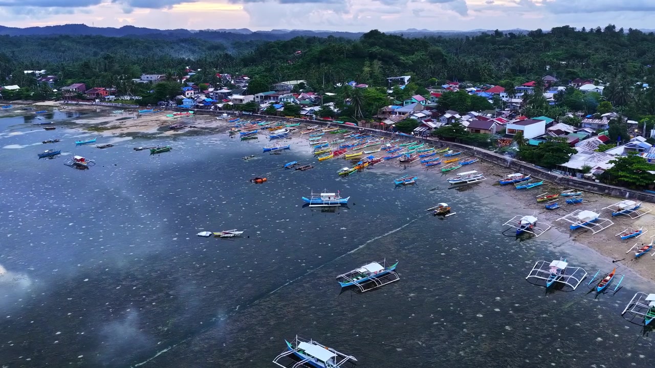 Perahu bangka tradisional bersandar di pelabuhan desa pesisir saat badai di Filipina