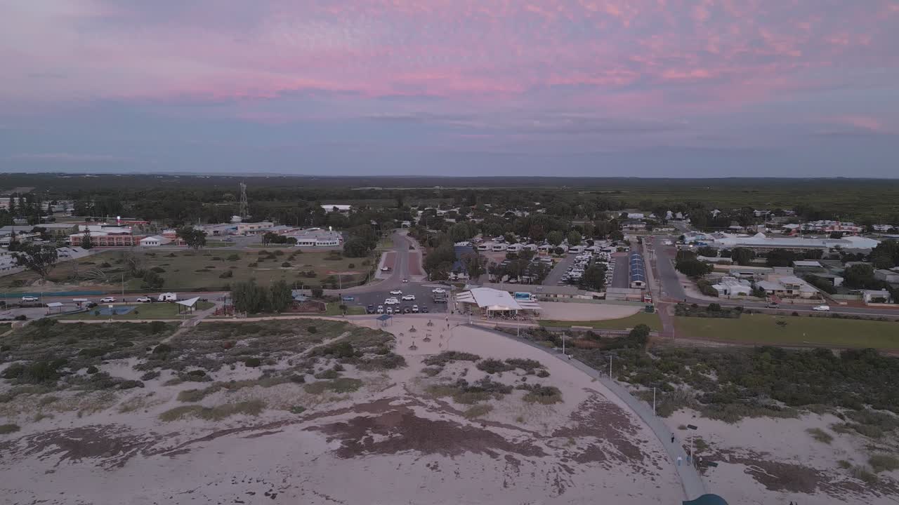 Cinematic drone footage panning towards and upwards from the Jurien Bay Jetty to reveal the remainder of the town at sunset