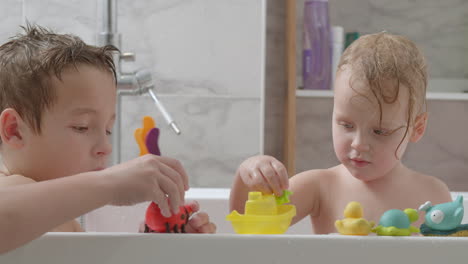 hermanos tomando un baño y jugando con juguetes