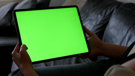 la mujer se queda en casa y mira a la pantalla verde de la tableta mostrar video 4k