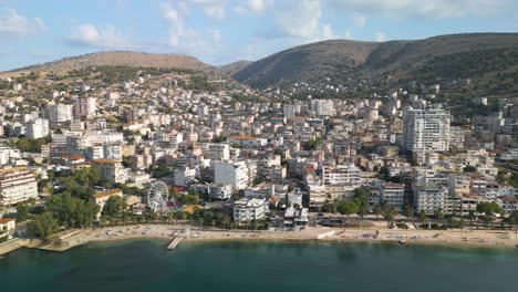 Aerial-Sliding-Shot-Reveals-Saranda,-Albania-Coastline-on-Typical-Summer-Day