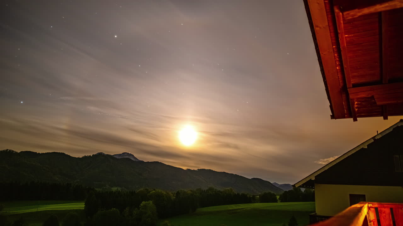 알프스 산맥의 집에서 해가 지는 동안 타임  ⁇ 스, 태양 주위의 가짜 헤로, 낮은 계층 구름이 지나간다