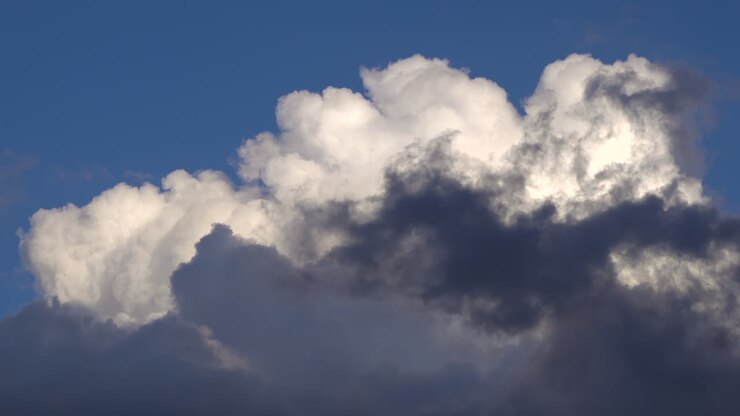 White and grey clouds moving on the blue sky