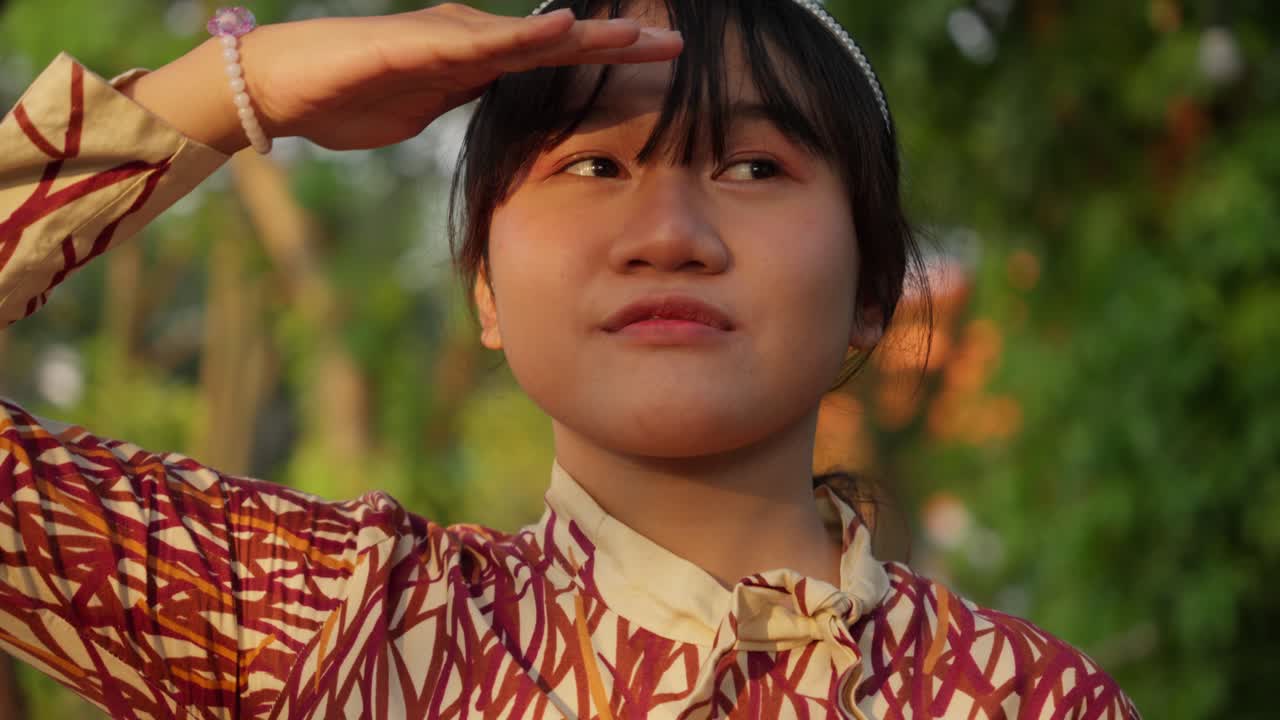 Happy Indonesian girl enjoying sunshine with her hands