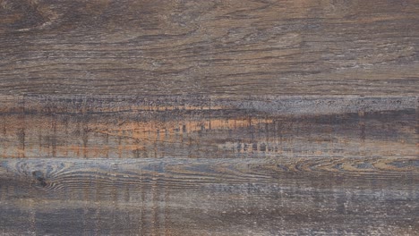 macro pan reveals worn tabletop grain and deep rustic marks